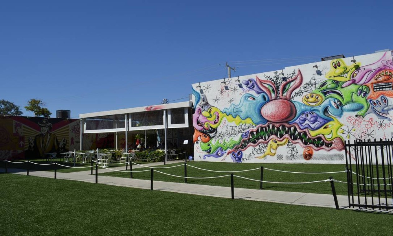 A entrada de Wynwood Walls, que exibe muros pintados por diversos artistas, incluindo o multicolorido de Kenny Scharf e as caricaturas de Shepard Fairy, que cercam o restaurante do local Foto: Cristina Massari / Agência O GLOBO