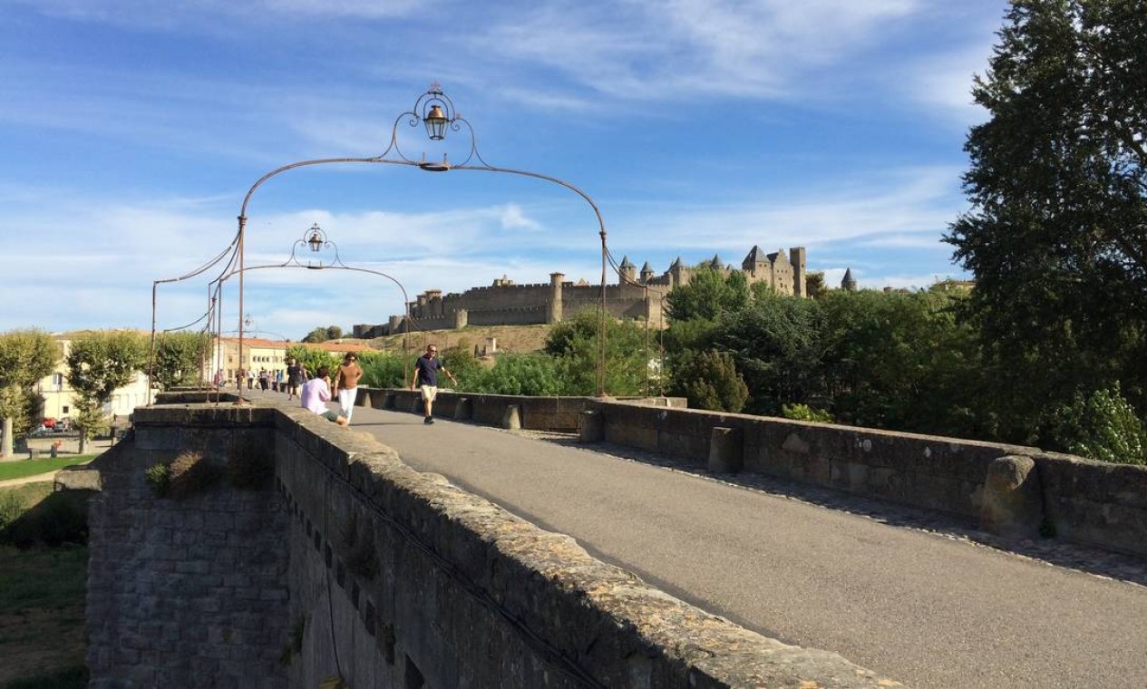 Turistas passeiam na ponte que leva atéa a Cité, em Carcassonne, na França Foto: Alina Hartounian / AP