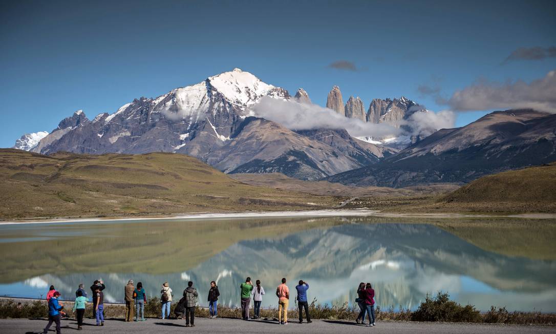 Turistas fotografam os picos de Torres del Paine, a quase dois mil quilômetros ao sul de Santiago, no parque nacional que faz parte da Rota dos Parques da Patagônia, no Chile Foto: MARTIN BERNETTI / AFP/26-2-2016