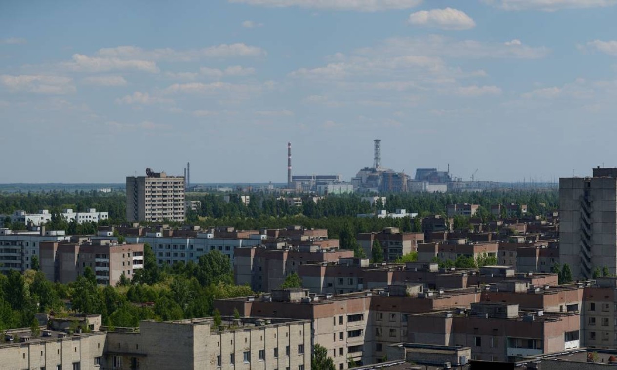 A cidade de Pripyat, vizinha à usina e construída para dar suporte a ela. A usina pode ser vista ao fundo. Pripyat tinha uma população estimada em 49 mil pessoas na época do desastre Foto: Wikimedia Commons