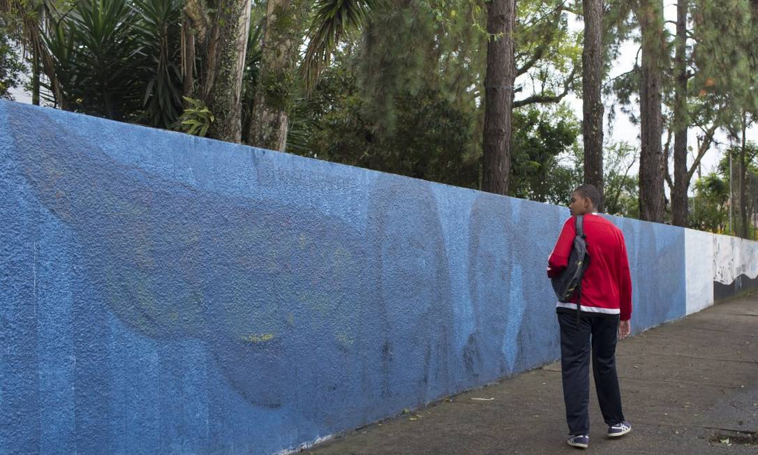 Muro grafitado com os rostos das vítimas do massacre na escola Raul Brasil, em Suzano, foi pintado de azul, após reclamação de pais e alunos; contornos ainda estão aparentes Foto: Edilson Dantas/9-4-2019 