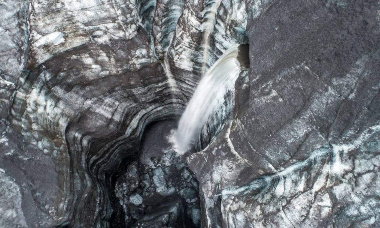 "Encontrei um rio sub-glacial vindo de dentro da geleira e caindo neste grande buraco. A longa exposição de cima dá uma nova perspectiva, é difícil saber onde estamos", escreveu Ledoux Foto: Florian Ledoux