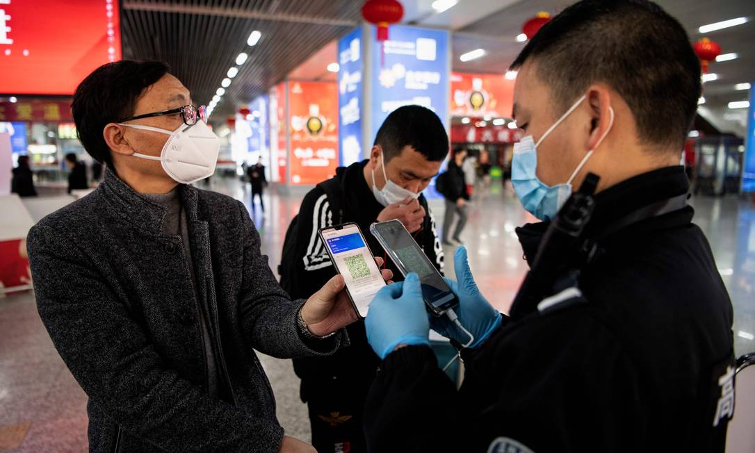 Passageiro mostra seu QR code para segurança na estação de trem de Wenzhou Foto: NOEL CELIS / AFP
