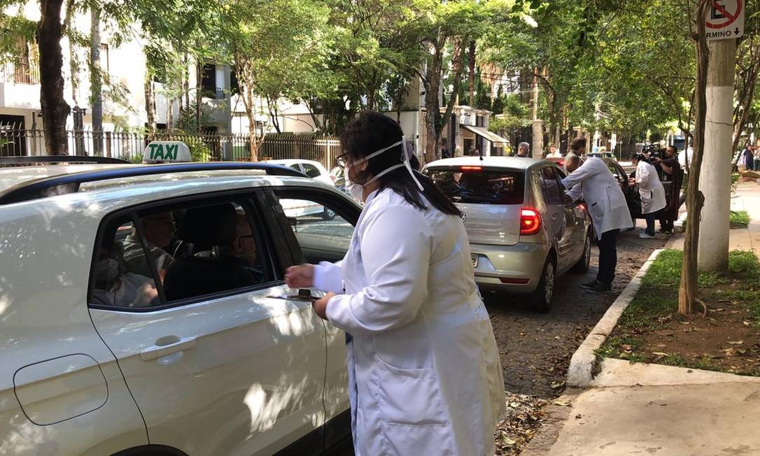 Profissional de saúde aplica vacina em idoso em carro: esquema 'drive thru' no início da campanha contra a gripe em SP Foto: Luiza Vaz/ TV Globo/Reprodução