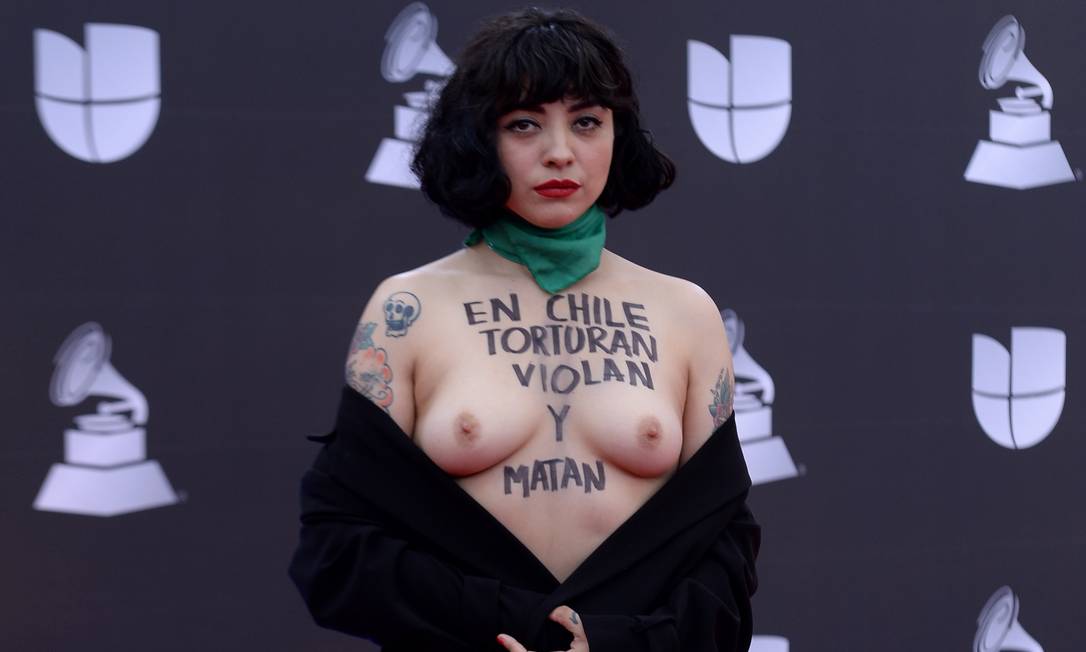 A cantora chilena Mon Laferte mostra os seios com a mensagem "No Chile, torturam, estupram e matam", no tapete vermelho da festa do Grammy Latino, em Las Vegas, nos Estados Unidos. Foto: BRIDGET BENNETT / AFP