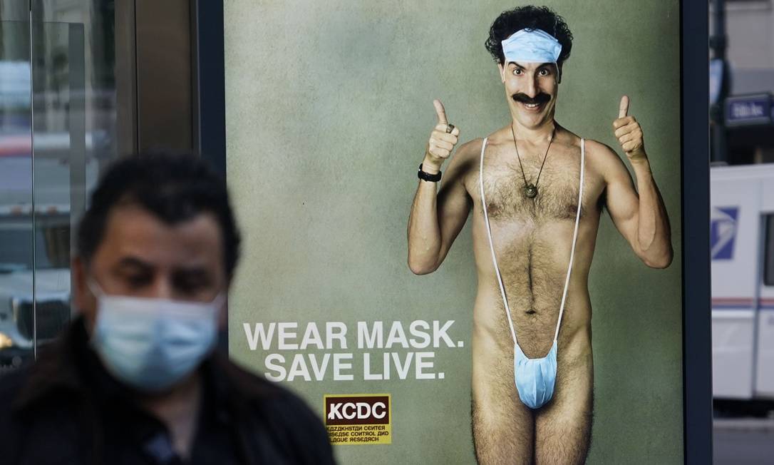 Homem passa por cartaz do filme "Borat 2", em Nova York, protagonizado por Sach Baron Cohen Foto: TIMOTHY A. CLARY / AFP