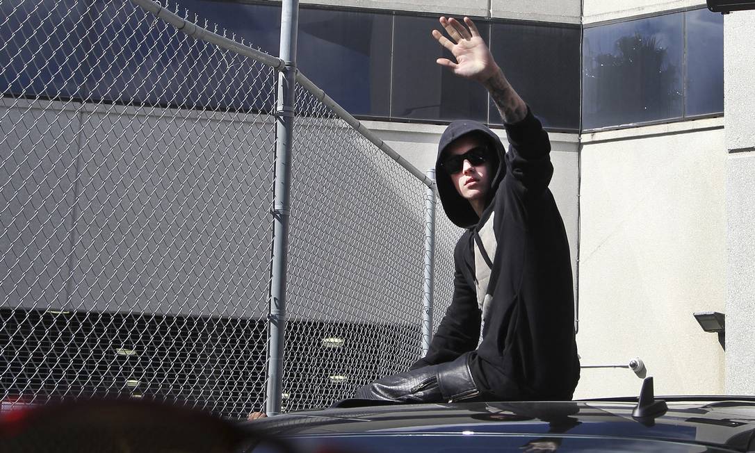 Cantor Justin Bieber acena para os fãs ao deixar o presídio Turner Guilford Knight, em Miami, nesta quinta-feira Foto: CW Griffin / REUTERS