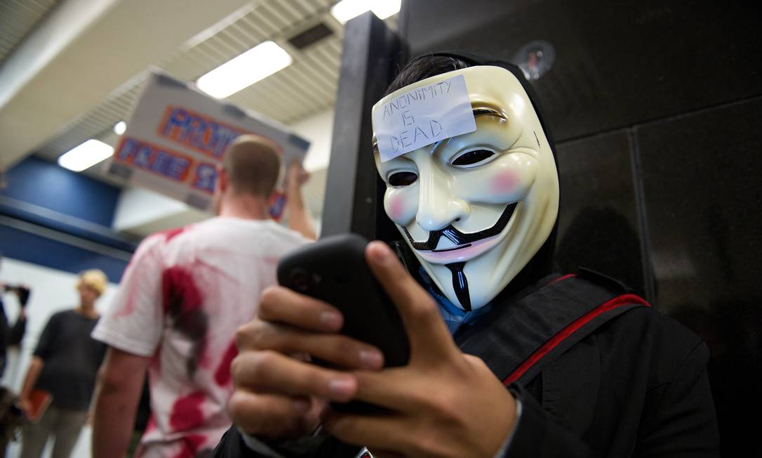 A demonstrator wearing a Guy Fawkes mask types on his mobile phone as he joins members of the Internet group known as Anonymous to demonstrate in the Civic Center Bay Area Rapid Transit (BART) station in San Francisco, California, U.S., on Monday, Aug. 15, 2011. The demonstration followed BART's move on Aug. 11 to temporarily restrict mobile-phone service on its train platforms in San Francisco in an effort to ward off protests. Photographer: David Paul Morris/Bloomberg Foto: David Paul Morris / Bloomberg