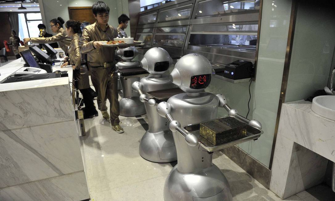 A man puts dishes on robots for delivery at a restaurant in Hefei, Anhui province, December 26, 2014.
The restaurant, with a space of 1300 square metres and a total of 30 robots to cook meals, deliver dishes and welcome costumers, was reported to be the biggest robot restaurant in China. REUTERS/STRINGER (CHINA - Tags: SOCIETY BUSINESS FOOD SCIENCE TECHNOLOGY) CHINA OUT. NO COMMERCIAL OR EDITORIAL SALES IN CHINA Foto: JIANAN YU / REUTERS
