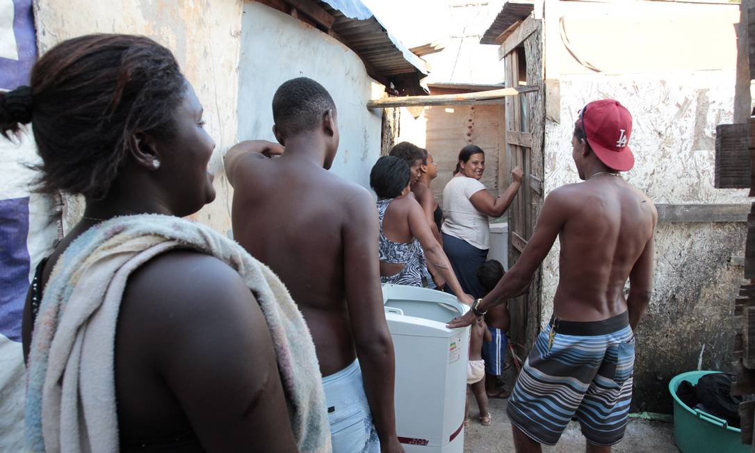 Brasil atingiu 7 de 8 metas do milênio. Mas ainda há desafios: moradores de um acampamento em Santa Cruz fazem fila para o uso do único banheiro Foto: Roberto Moreyra / Agência O Globo