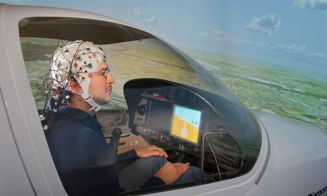 Pesquisador Guillermo Falconi com capacete EEG em simulador de voo Diamond comandado por sinais cerebrais Foto: Andreas Heddergott / Divulgação TU München