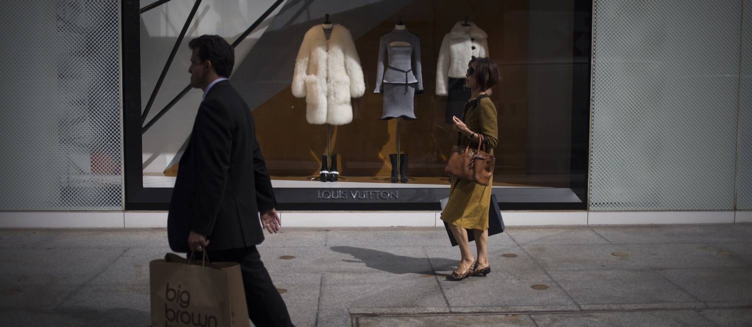 Pedestres passam em frente à loja da Louis Vuitton na 5ª Avenida, em Nova York: roupas, calçados e acessórios podem ser taxados Foto: John Taggart / Bloomberg