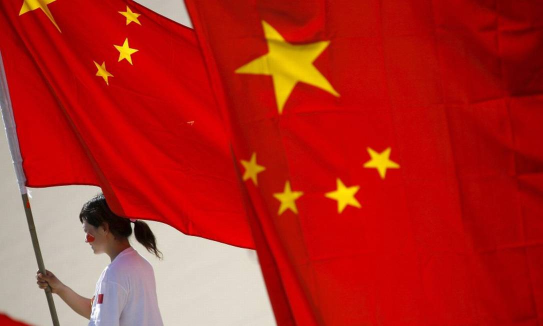 Mulher levando bandeira da China Foto: Oliver Weiken / EFE