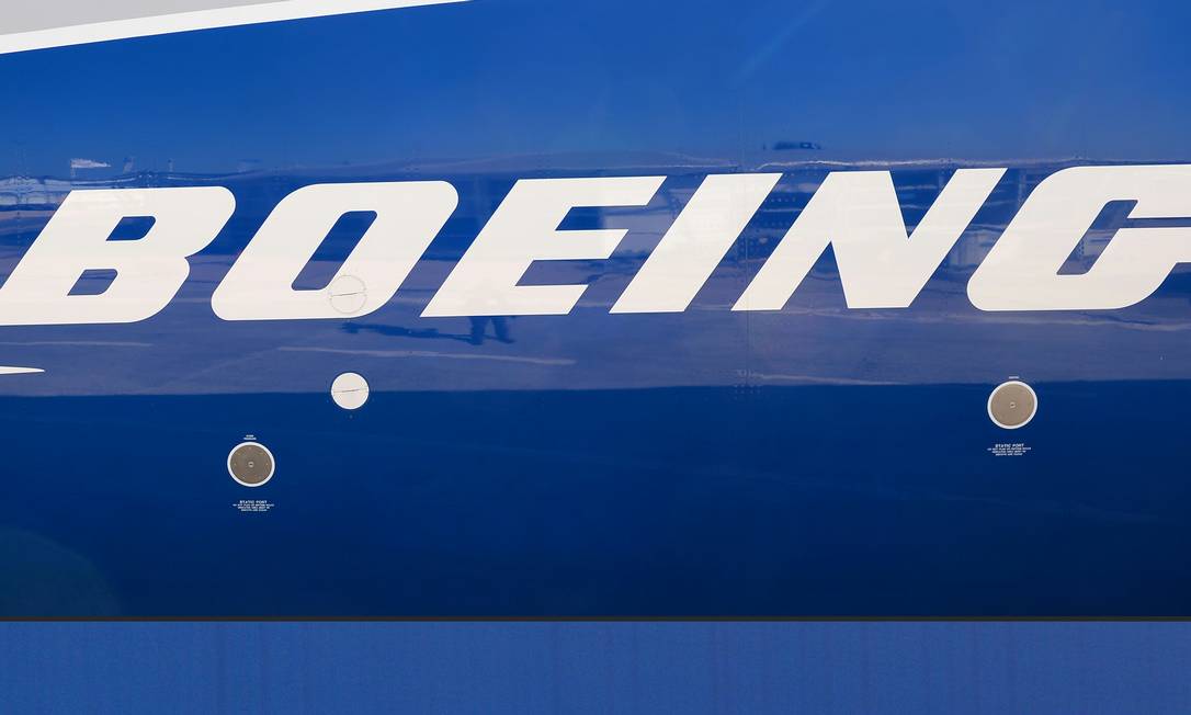Montagem com os logos da Boeing e Embraer, que discutem parceria
Foto: ERIC PIERMONT / AFP