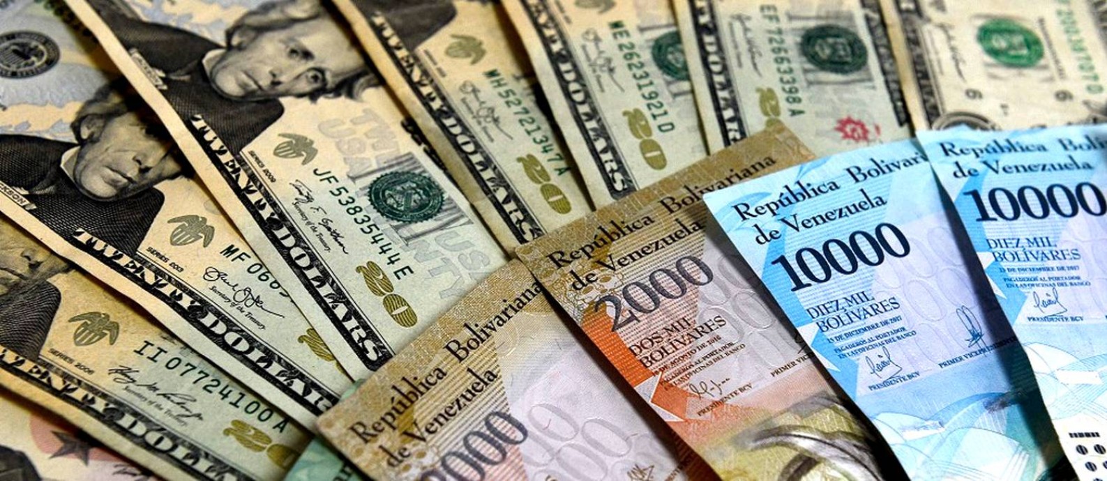 Notas de Bolívar venezuelano e de dólar Foto: FEDERICO PARRA / AFP