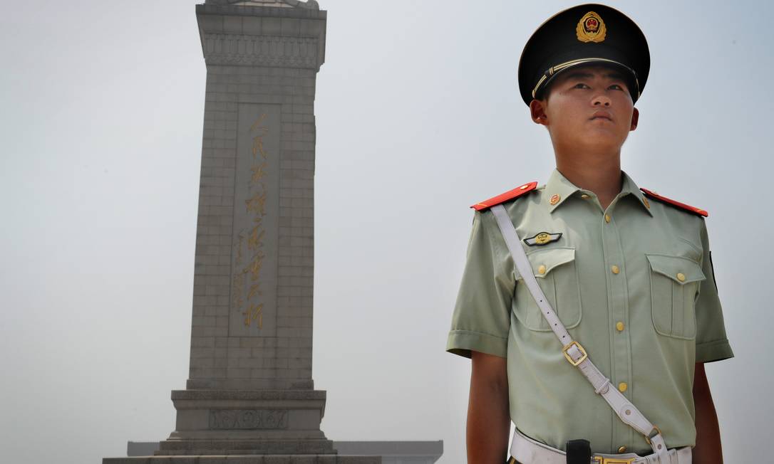Policial chinês em frente ao Monumento aos heróis do povo, em Pequim Foto: MARK RALSTON / AFP/Getty Images