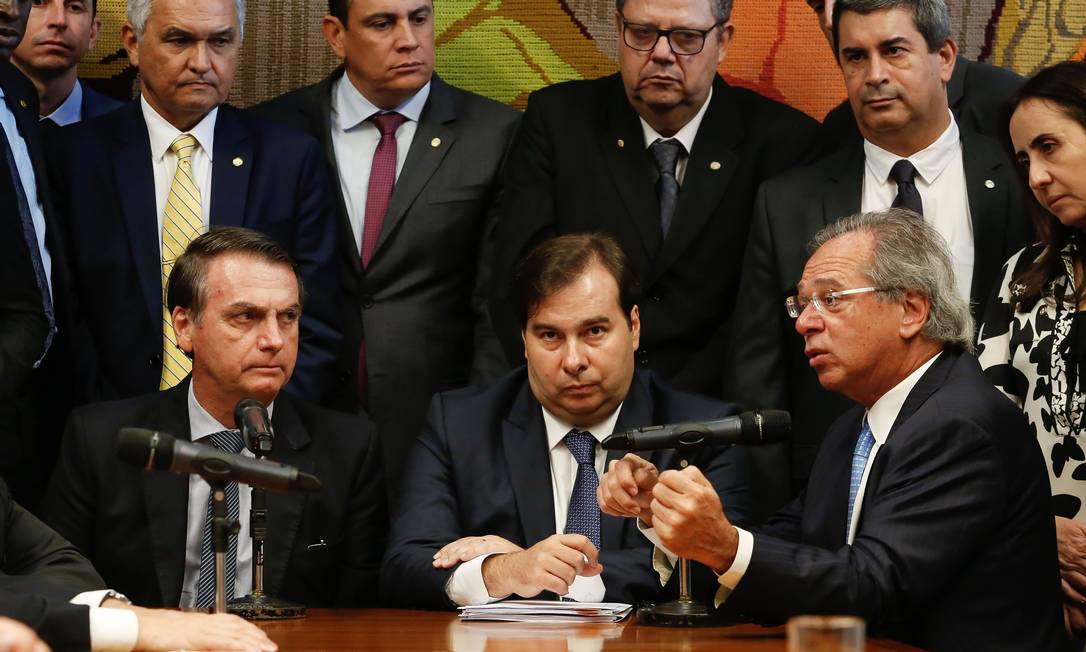 Handout picture released by Brazilian Presidency showing Brazilian President Jair Bolsonaro (L) Lower House President Rodrigo Maia (C) and Economy Minister Paulo Guedes during the presentation of the proposal of the new military pension plan at the National Congress in Brasilia, Brazil, on March 20, 2019. - Bolsonaro has made privatizing state-owned companies and overhauling the costly pension system key planks of his policy to reduce soaring public debt and regain investor faith in Latin America's largest economy. (Photo by CAROLINA ANTUNES / BRAZILIAN PRESIDENCY / AFP) / RESTRICTED TO EDITORIAL USE - MANDATORY CREDIT 'AFP PHOTO / BRAZILIAN PRESIDENCY - Carolina ANTUNES' - NO MARKETING - NO ADVERTISING CAMPAIGNS - DISTRIBUTED AS A SERVICE TO CLIENTS Foto: CAROLINA ANTUNES / AFP