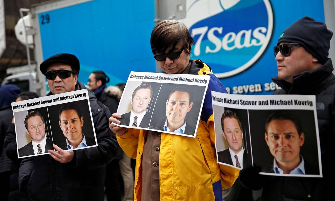 Pessoas seguram cartazes pedindo à China para libertar os canadenses Michael Spavor e Michael Kovrig do lado de fora de uma audiência na Suprema Corte em Vancouver, Canadá Foto: Lindsey Wasson / REUTERS