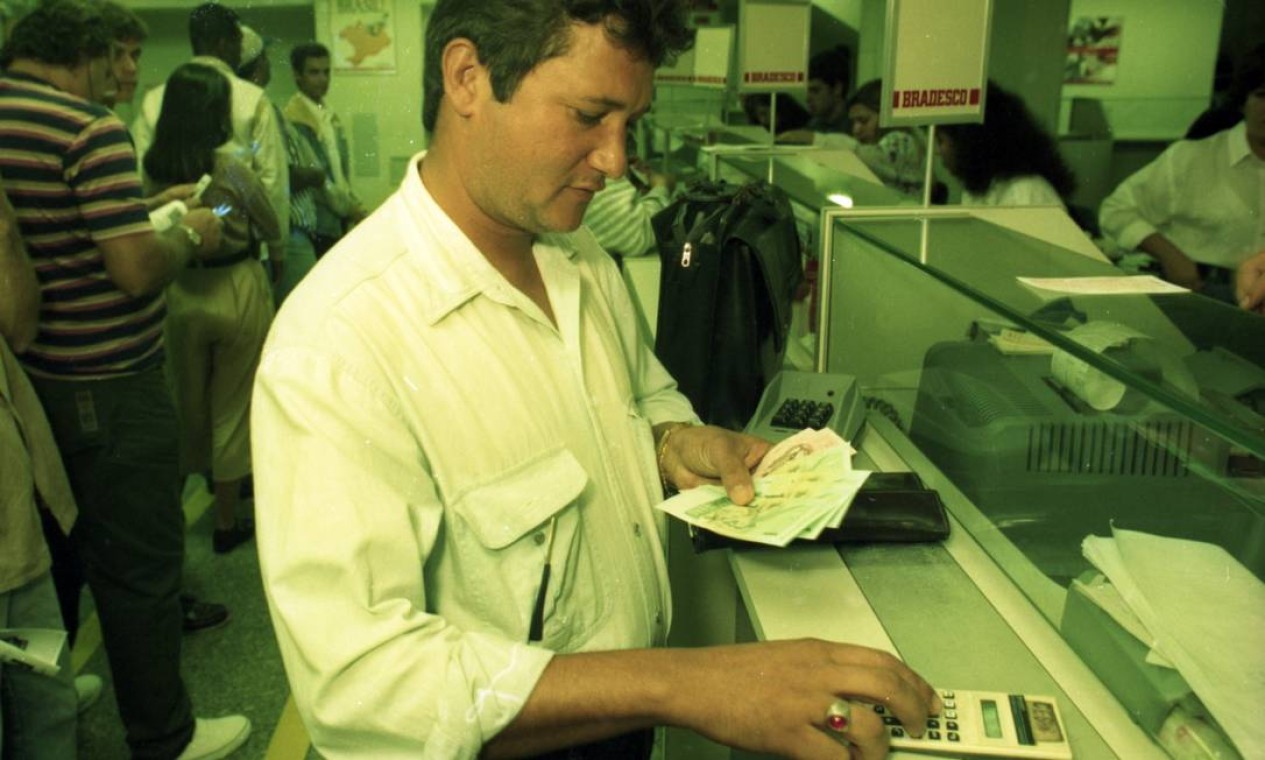 Após a entrada em vigor da nova moeda, os brasileiros foram aos bancos para trocar as notas de cruzado real pelo real. Na imagem, cliente de um banco no Rio fazendo a troca em 1º de julho de 1994 Foto: Agência O Globo