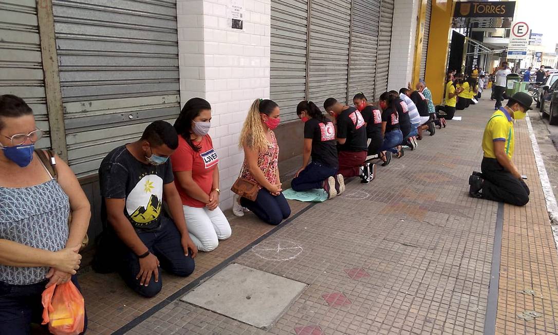 Trabalhadores ficaram de joelhos, próximos uns dos outros,
em um ato com louvores e orações que pedia a reabertura
do comércio em Campina Grande Foto: Terceiro / Agência O Globo