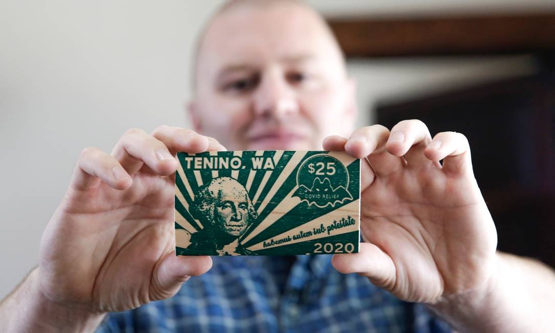 Prefeito de Tenino Wayne Fournier segurando uma nota de 25 "dólares Covid" Foto: Jason Redmond / AFP