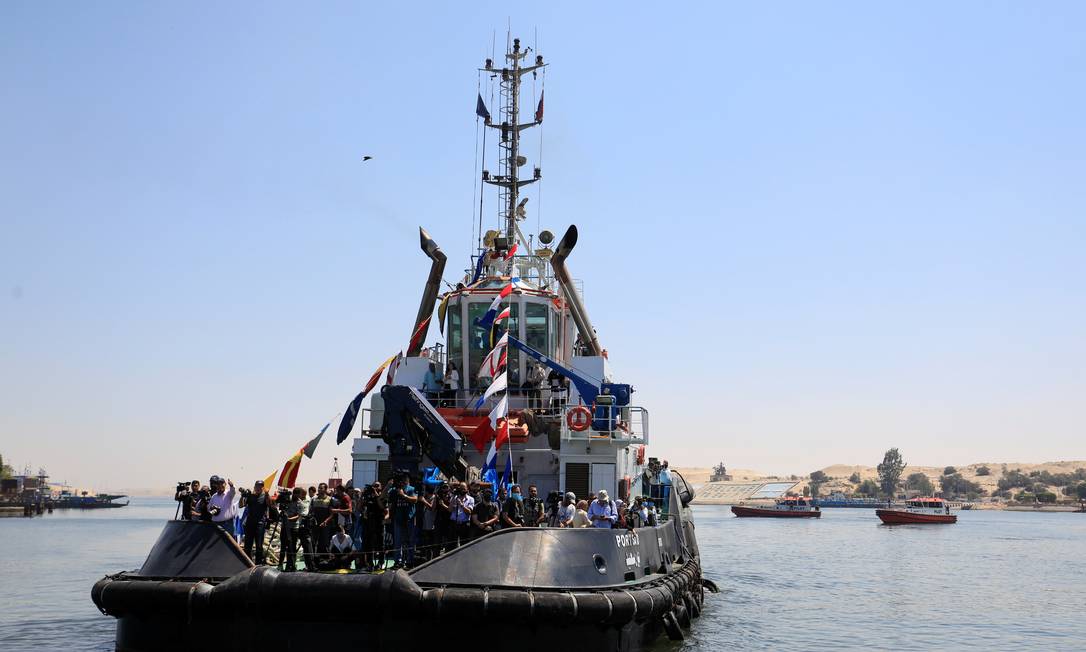 Repórteres, fotógrafos e cinegrafias viajam em um barco a caminho da área onde o Ever Given, um dos maiores navios de contêineres do mundo, inicia a operação para deixar o Canal de Suez Foto: AMR ABDALLAH DALSH / REUTERS