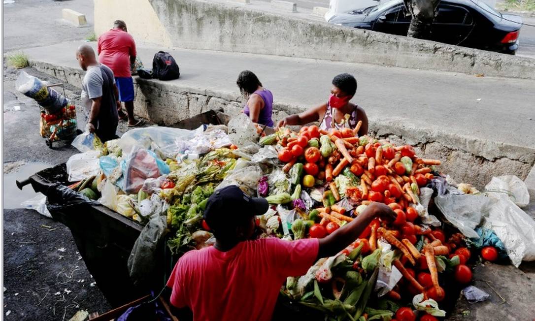 Pessoas buscam alimentos nas caçambas de lixo na Ceasa/RJ: novo programa que substituirá o Bolsa Família deve ser anunciado nesta terça Foto: Fabiano Rocha/Agência O Globo