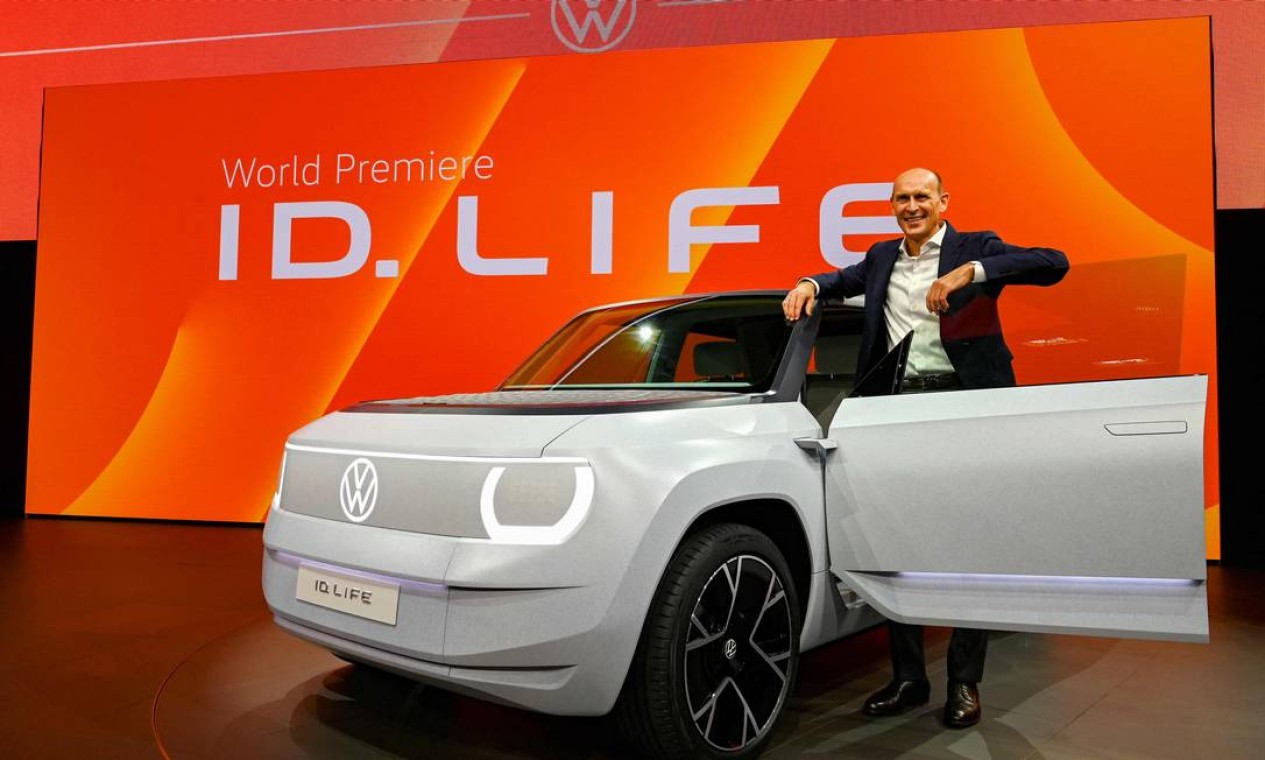 O gerente da Volkswagen, Ralf Brandstaetter, posa ao lado de um carro elétrico da marca o VW ID.Life Foto: CHRISTOF STACHE/AFP