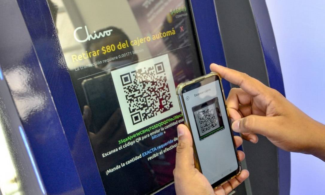 Salvadorenho faz operação com bitcoin em caixa eletrônico Foto: Bloomberg