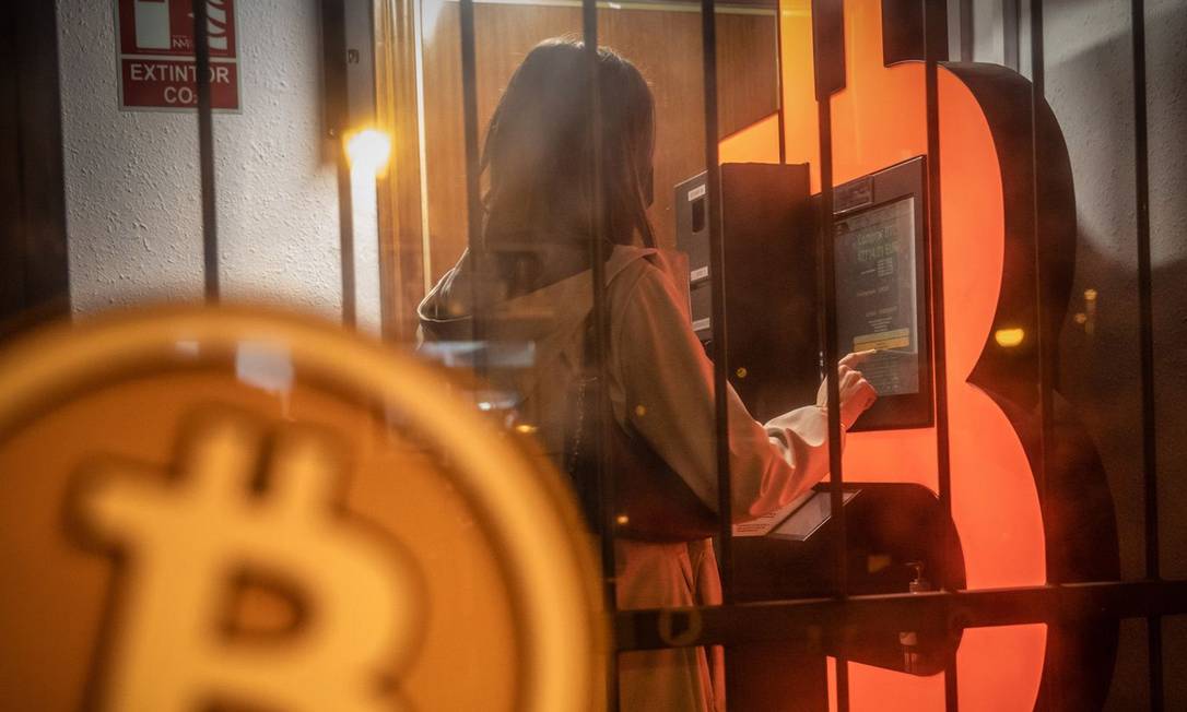 Uma cliente usa um caixa eletrônico de bitcoin em um quiosque de Barcelona, Espanha Foto: Bloomberg