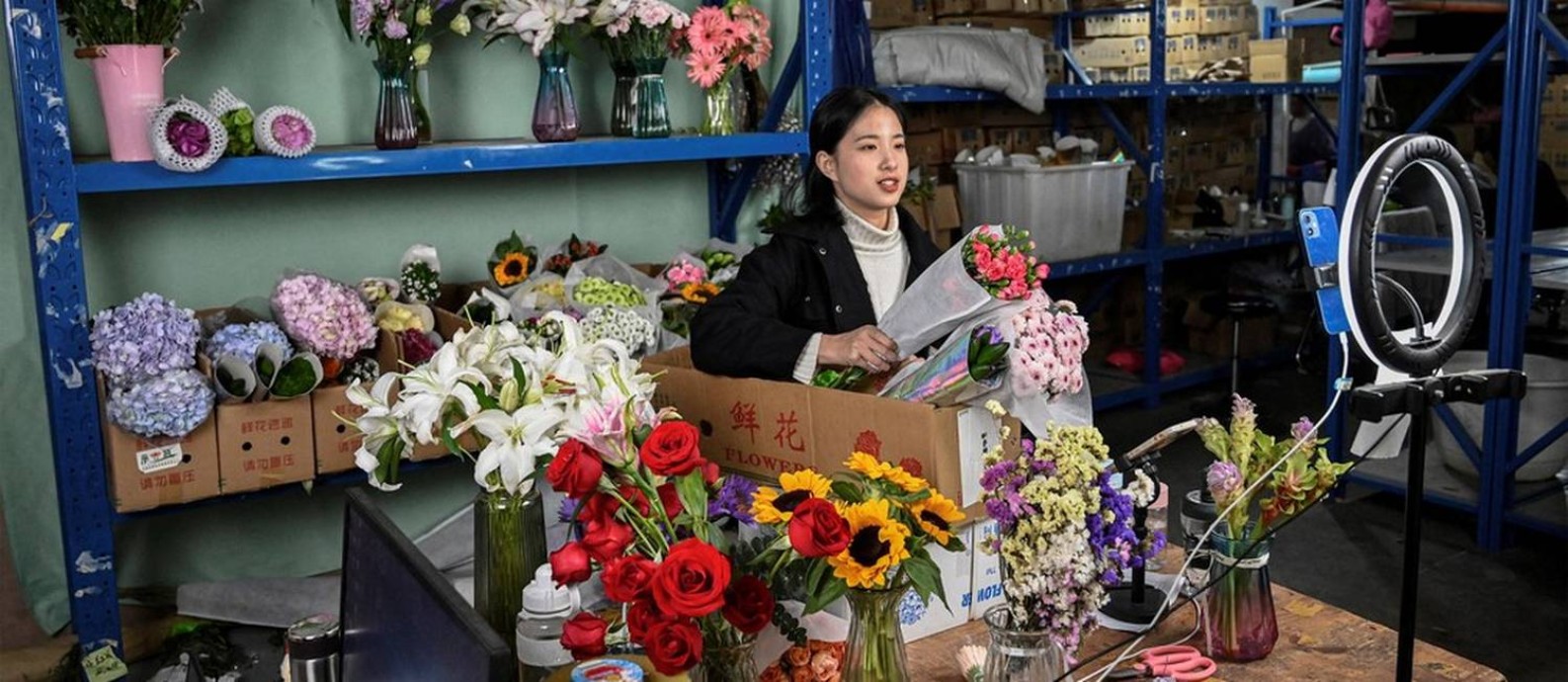 'Streamer' Cai Cai vende flores em estúdio improvisado no mercado de flores de Dounan Foto: AFP