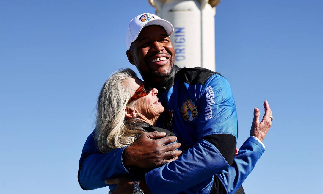 Ex-estrela da NFL Michael Strahan abraça Laura Shepard Churchley, filha do astronauta Alan Shepard, depois que voaram para o espaço a bordo do Blue Origins New Shepard Foto: MARIO TAMA / AFP
