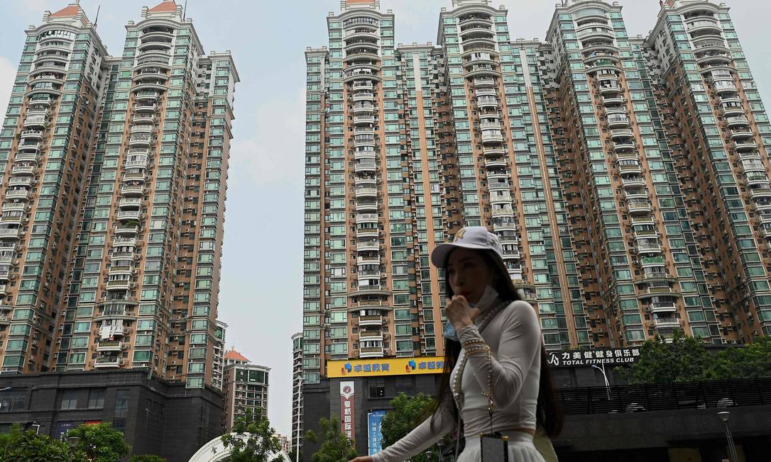 Foto mostra uma mulher passando por um complexo habitacional da incorporadora imobiliária chinesa Evergrande em Guangzhou, província de Guangdong, no sul da China Foto: NOEL CELIS / AFP