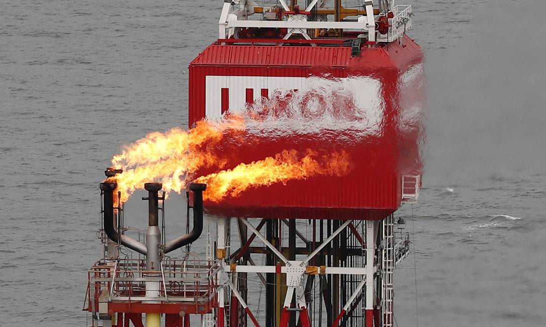 Uma tocha de gás é vista ao lado da placa da empresa Lukoil na plataforma de petróleo Filanovskogo no Mar Cáspio, Rússia Foto: Maxim Shemetov / REUTERS