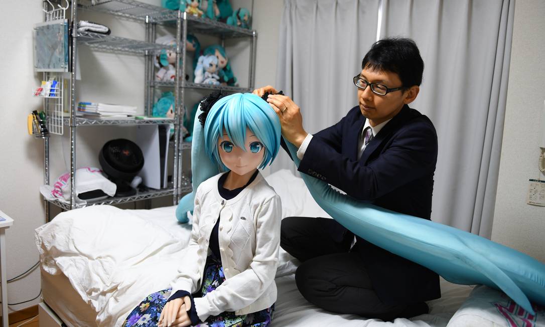 Akihiko Kondo em casa em Tóquio com uma boneca em tamanho real de Hatsune Miku, a estrela pop virtual com quem se casou em 2018 Foto: Noriko Hayashi / NYT