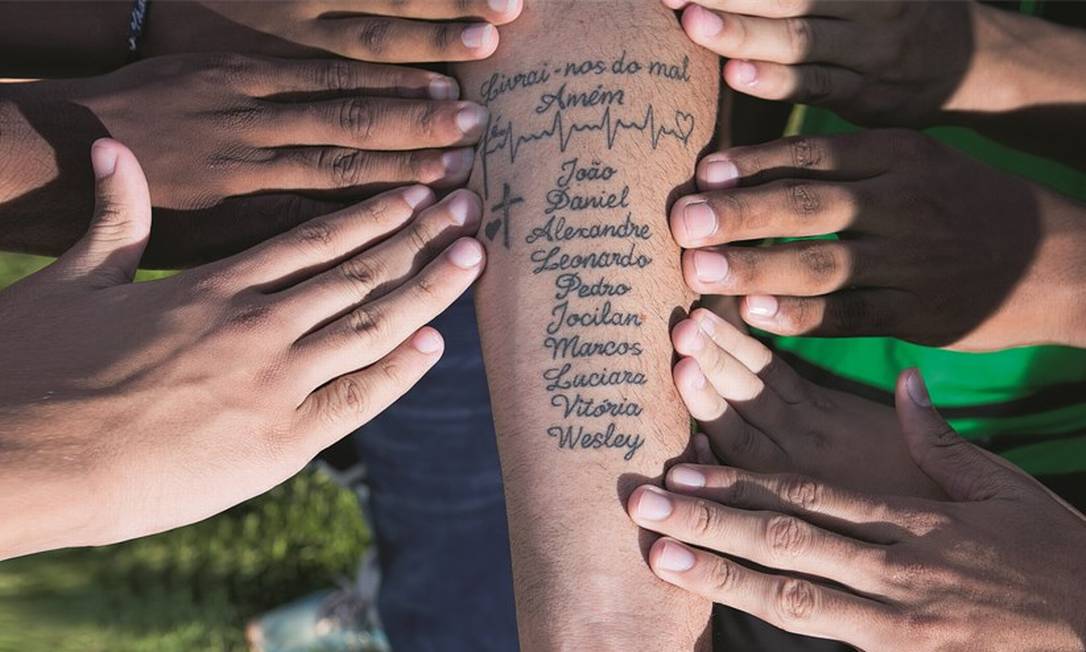 O enfermeiro Uanderson Barreto de Souza tatuou no braço os nomes das dez crianças para evitar esquecimentos. Foto: Mauro Souza / Agência O Globo