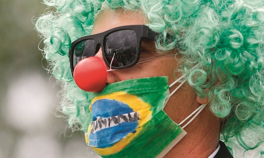 Um apoiador de Jair Bolsonaro se veste de palhaço e usa máscara em protesto em Brasília, no dia 15. O presidente esteve presente. Foto: Sergio Lima / AFP