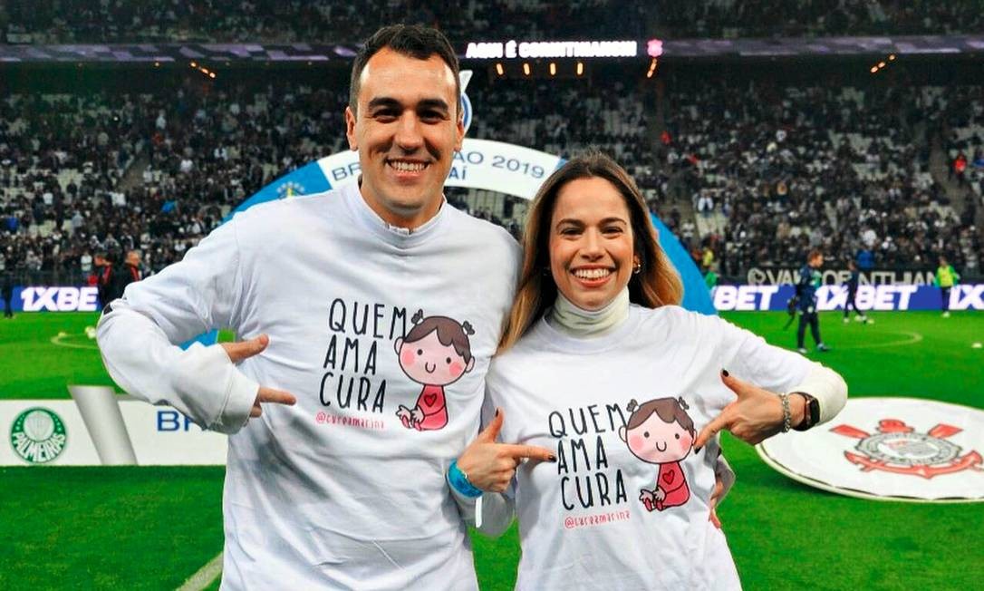 Renato e Talita no lançamento da campanha para arrecadar fundos para Marina, em 2019, durante um jogo entre Palmeiras e Corinthians, no Itaquerão. Foto: Arquivo pessoal / Reprodução