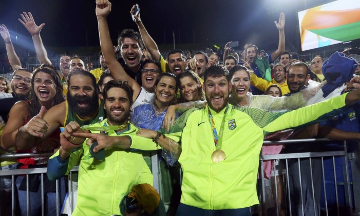 Bruno e Alison comemoram o ouro com o público que foi assistir à partida em Copacabana Foto: MURAD SEZER / REUTERS