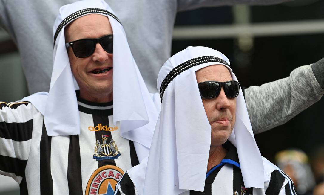 Fãs cobrem a cabeça, em homenagem a nova parceria do Newcastle com a Arábia Saudita Foto: PAUL ELLIS / AFP