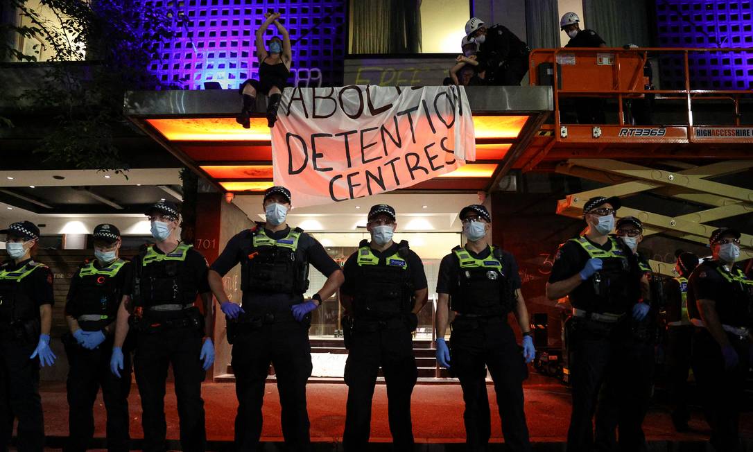 Policiais ficam de guarda enquanto manifestantes pr-refugiados so removidos de um toldo no Park Hotel, onde o jogador de tnis srvio Novak Djokovic est detido Foto: LOREN ELLIOTT / REUTERS