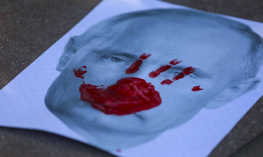 Cartaz mostra uma foto do presidente russo Vladimir Putin, em comício de apoio à Ucrânia em Santa Monica, Califórnia (EUA). Foto: RINGO CHIU / AFP
