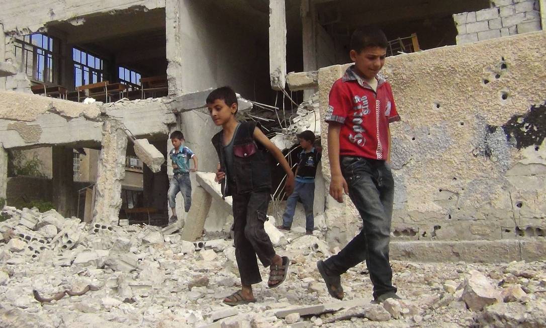 
Crianças andam entre os escombros de um edifício escolar destruído no subúrbio de Damasco
Foto: STRINGER / REUTERS