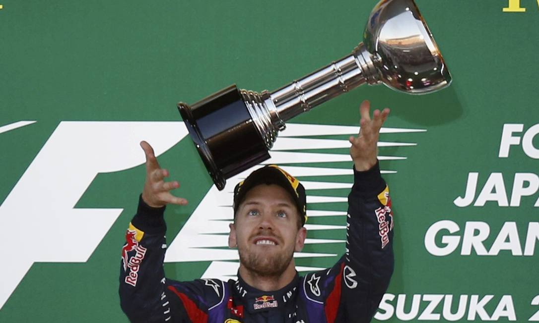Red Bull Formula One driver Sebastian Vettel of Germany receives his trophy after winning the Japanese F1 Grand Prix at the Suzuka circuit October 13, 2013. REUTERS/Toru Hanai (JAPAN - Tags: SPORT MOTORSPORT F1) Foto: TORU HANAI / REUTERS