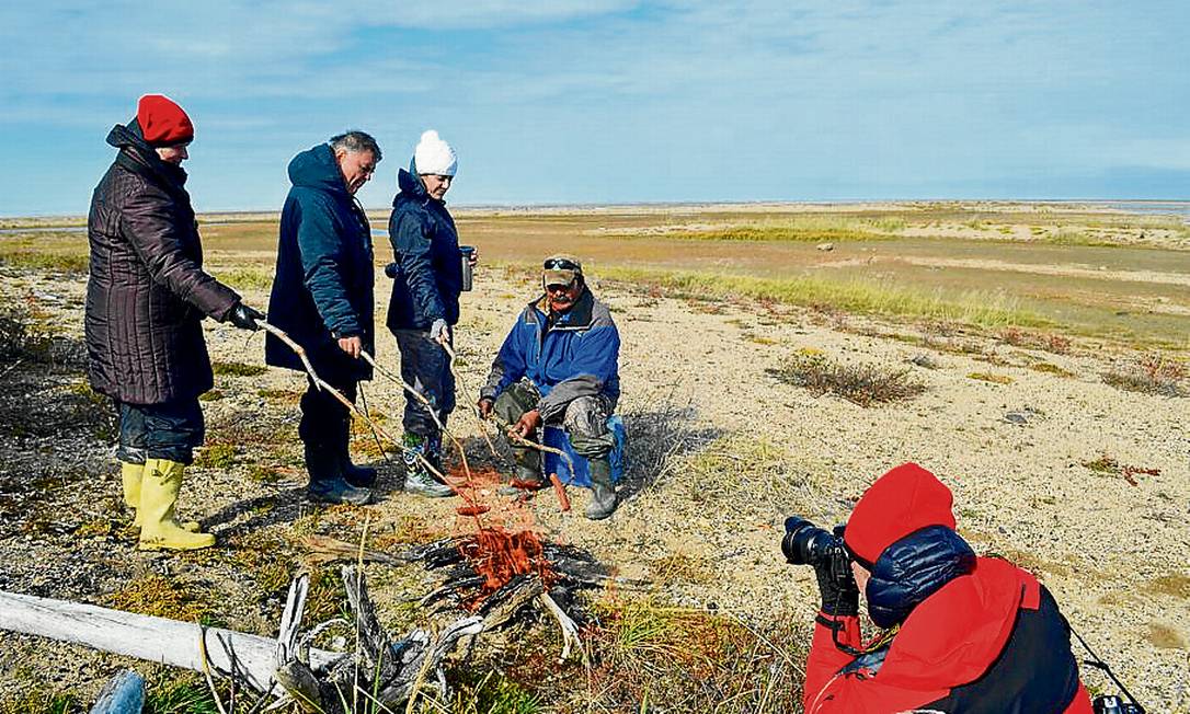 Temperatures are close to zero, but positive.  During the visit there is a fire to roast sausages for lunch Photo: Cristina Massari / O Globo