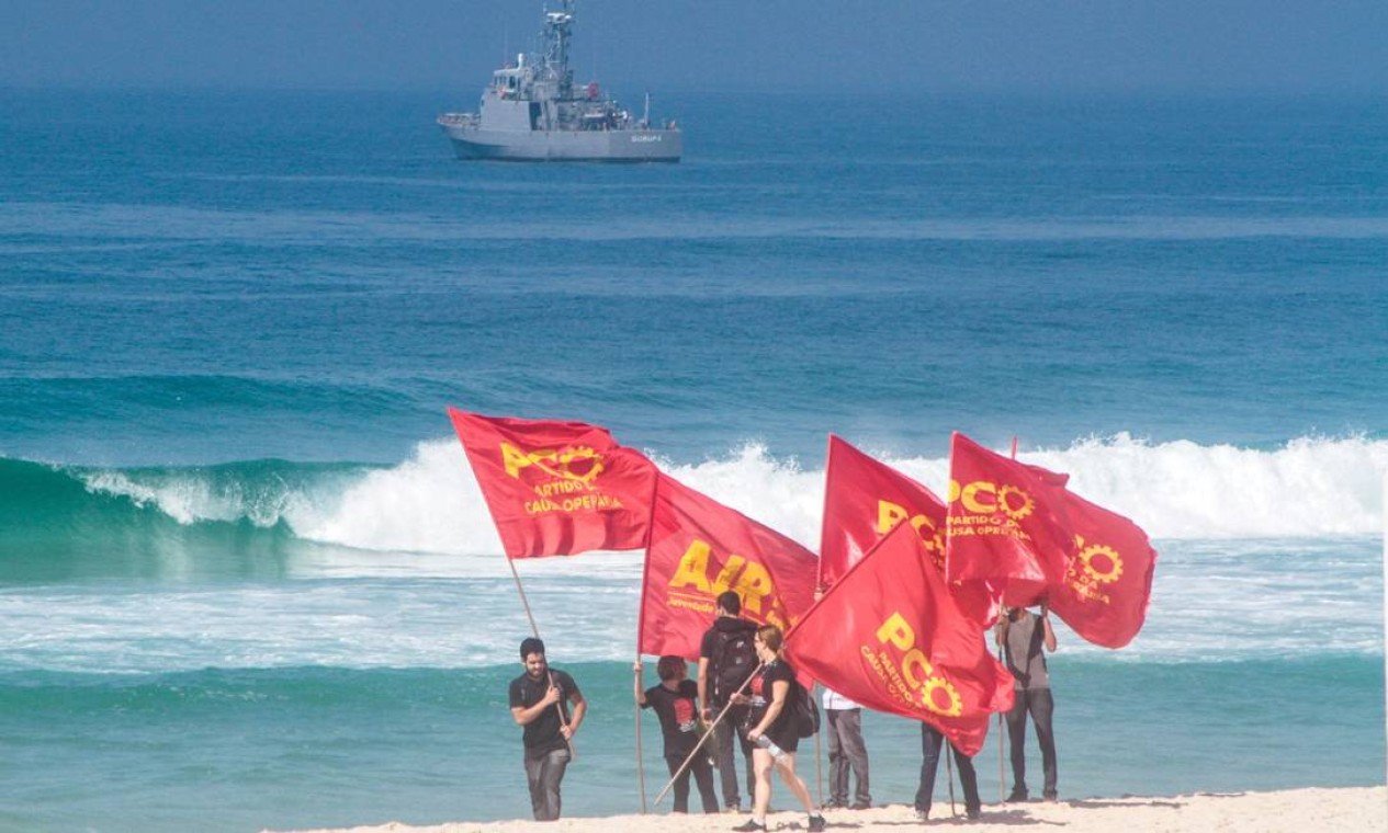 Manifestantes levando bandeiras de partidos caminham pela praia da Barra. Grupos entraram em confronto com forças de segurança Foto: Brazil Photo Press / Nestor Beremblum