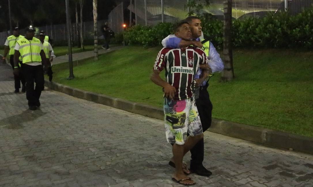 
Torcedor é levado por segurança do Maracanã. Saida do Fluminense do estádio foi confusa
Foto: Guilherme Pinto / Extra