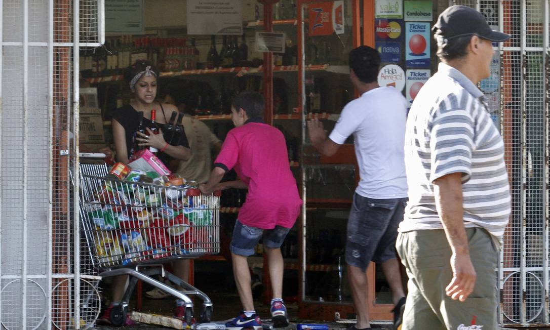 
Saqueadores deixam um supermercado em Córdoba, em 3 de dezembro
Foto: STR / AFP