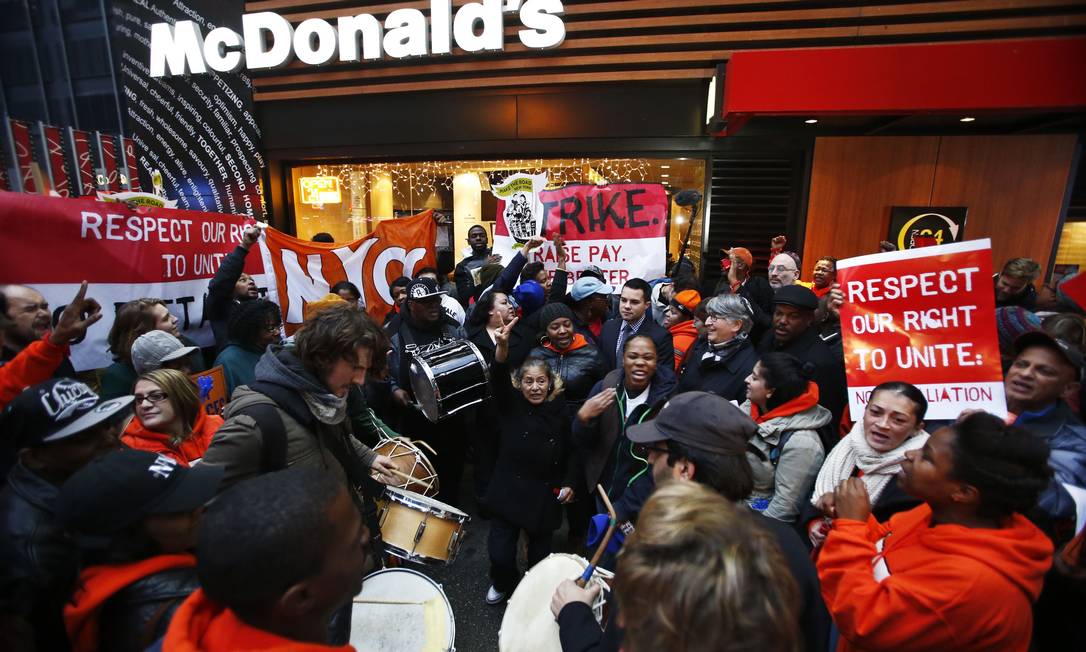 Trabalhadores protestam, com música, em frente a um dos restaurantes da rede de fast food McDonald's em Nova York Foto: EDUARDO MUNOZ / REUTERS