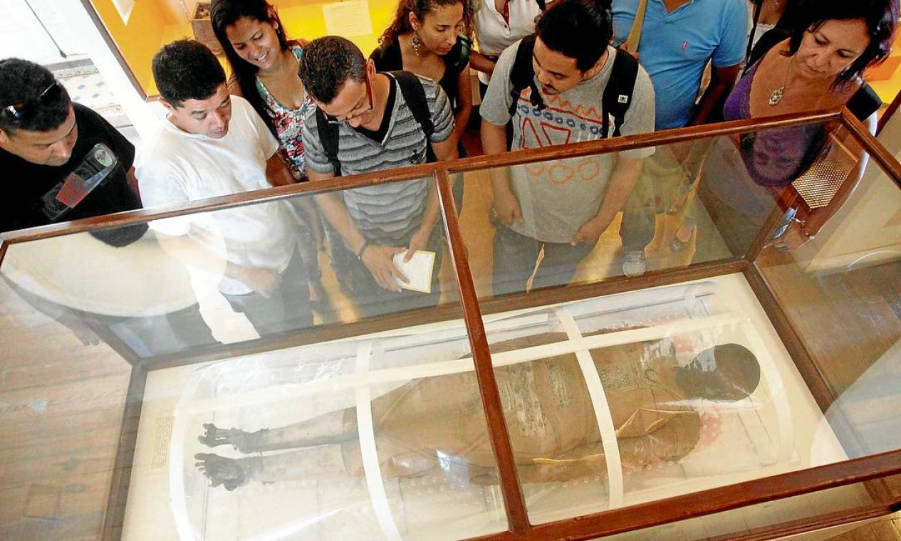 Visitantes observam Kherima, a peça mais popular do Museu Nacional: apenas nove múmias do mundo tiveram um tratamento externo do corpo tão detalhado Foto: Custódio Coimbra